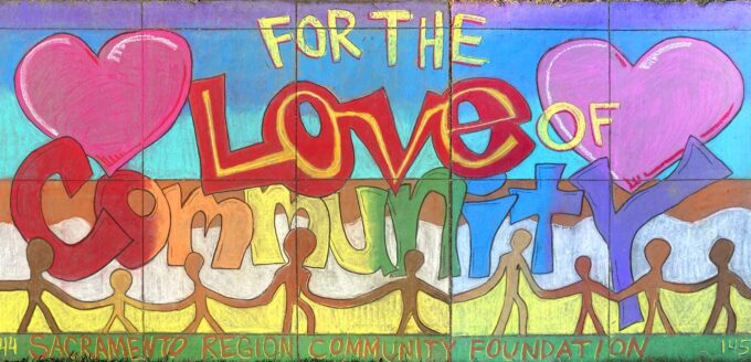 Chalk art on a sidewalk with hearts and people holding hands and the words "For the love of community"